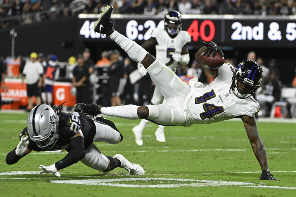 Las Vegas Raiders safety Tre'von Moehrig (25) tackles Baltimore Ravens wide receiver Sammy Watkins (14) during the second half of an NFL football game, Monday, Sept. 13, 2021, in Las Vegas. (AP Photo/David Becker)