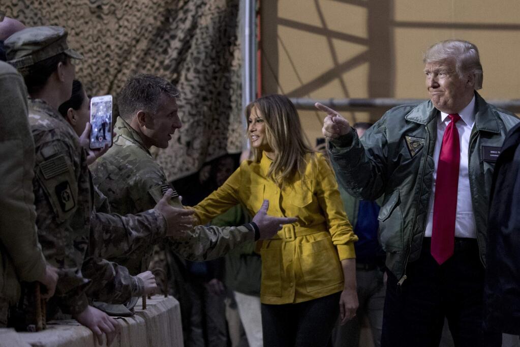 President Donald Trump and first lady Melania Trump greet members of the military at a hanger rally at Al Asad Air Base, Iraq, Wednesday, Dec. 26, 2018. (AP Photo/Andrew Harnik)