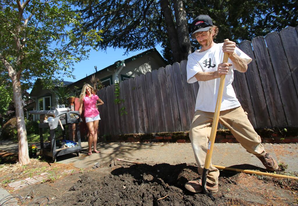 Wesley and Gina Halihan prepare to plant flowers on the side of their Brown Street home, in Santa Rosa on Thursday, July 3, 2014. The Halihans purchased the home from James and Lara Castle, who allegedly hid an undisclosed amount of debt through a forged reconveyance. The Halihans have had a lien on their home since they purchased it in 2009. (Christopher Chung/ The Press Democrat)