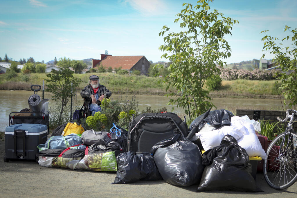 James Johnson sits amongst  the belongings that he and other homeless residents chose to keep after the Petaluma police rousted residents from an encampment at Steamer Landing Park on Friday, April 30, 2021. (CRISSY PASCUAL/ARGUS-COURIER STAFF)