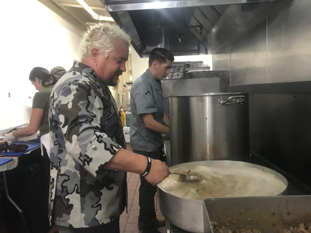 Guy Fieri cooks meals for first responders who have battled the Kincade fire with his son, Hunter, at the Sonoma County Fairgrounds in Santa Rosa on Thursday, Oct. 31, 2019. (Elissa Chudwin/ The Press Democrat)