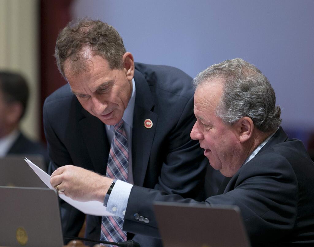 Democratic state Senators Bob Wieckowski, of Fremont, left, and Bill Dodd, of Napa, confer at the Capitol Wednesday, Sept. 6, 2017, in Sacramento, Calif. The Senate approved Dodd's measure, SB33, that could require Wells Fargo to go to court over its fake account scandal instead relying in contract provisions by prohibiting the bank from relying on contracts that say disputes must be settled through arbitration. The bill now goes to the governor. (AP Photo/Rich Pedroncelli)