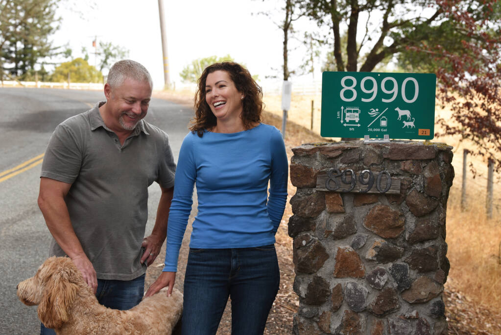 Brant Claussen, left, and Joanie Benedetti Claussen with their fire safe sign at the entrance to their home in Cotati, Calif. on Saturday, July 3, 2021. The couple have created a sign system to help first responders with critical property information during fires and other emergencies.(Photo: Erik Castro/for The Press Democrat)