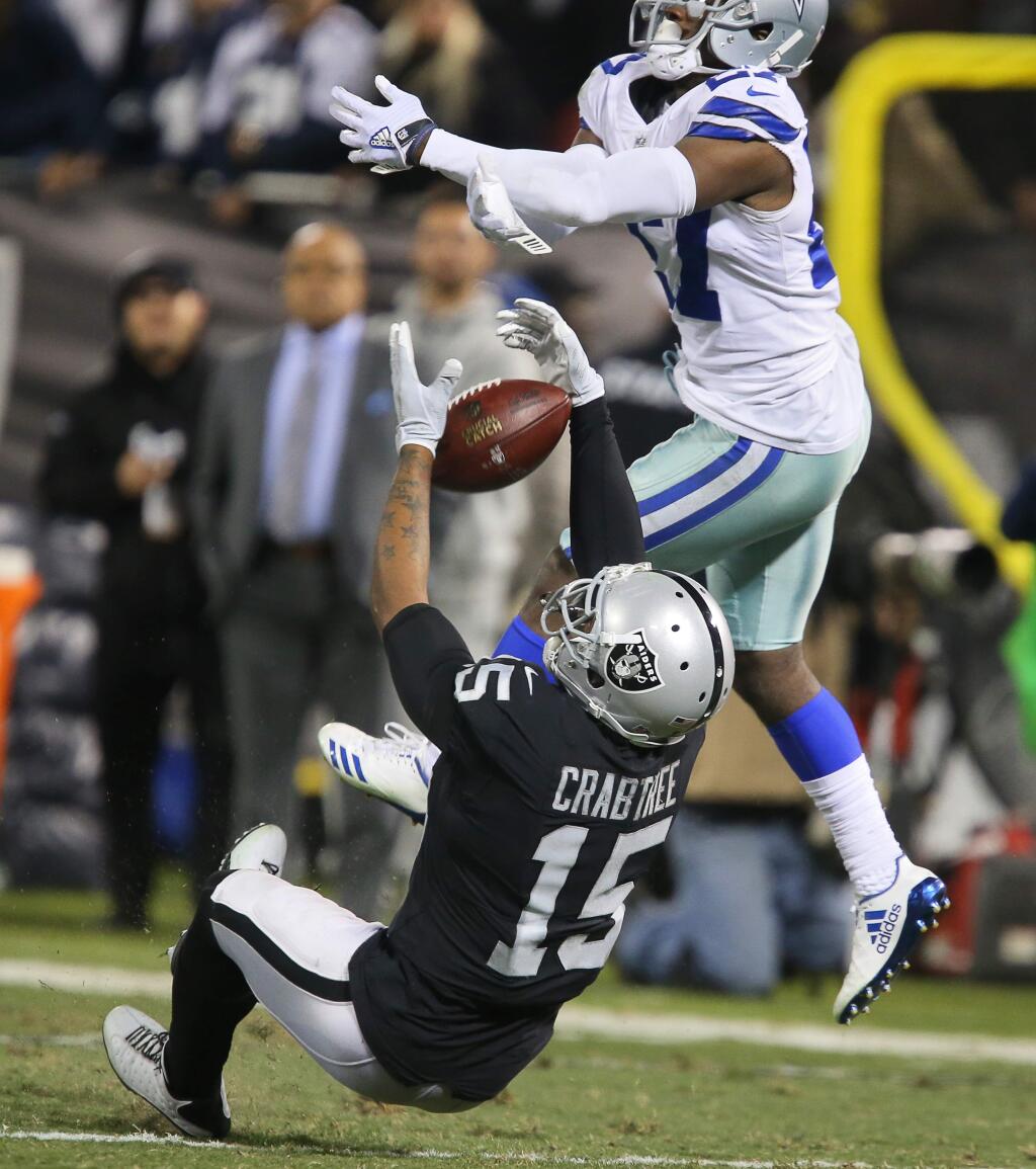 Oakland Raiders wide receiver Michael Crabtree is unable to hang onto a pass, as Dallas Cowboys cornerback Jourdan Lewis is called for pass interference, during their game in Oakland on Sunday, December 17, 2017. The Raiders lost to the Cowboys 20-17.(Christopher Chung/ The Press Democrat)