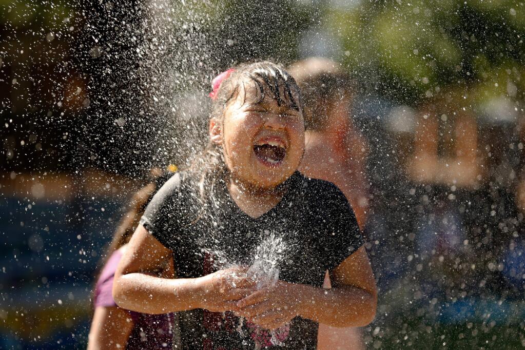 Jacqueline Villanueva, 8, reacts as she is hit with a jet of water shooting up from the ground at the water feature in Prince Gateway Park in Santa Rosa, California, on Tuesday, May 2, 2017. (ALVIN JORNADA/ PD)