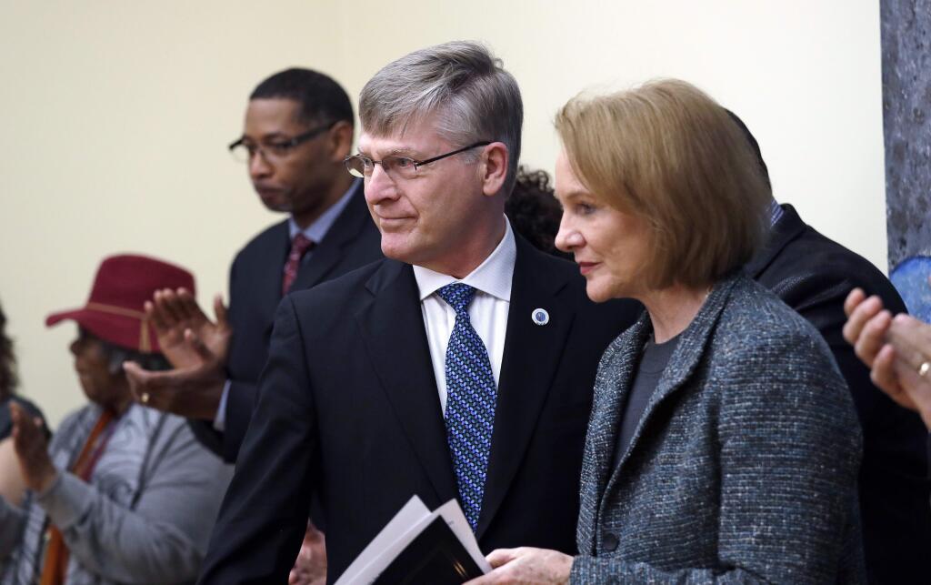 Seattle City Attorney Pete Holmes, left, steps back after speaking as Mayor Jenny Durkan moves to the microphone at a news conference announcing plans for the city to move to vacate misdemeanor marijuana possession convictions, Thursday, Feb. 8, 2018, in Seattle. City Council-member Bruce Harrell looks on at right. Five years after Washington state legalized marijuana, Seattle officials say they're moving to automatically clear past misdemeanor convictions for pot possession. San Francisco recently took the same step. (AP Photo/Elaine Thompson)
