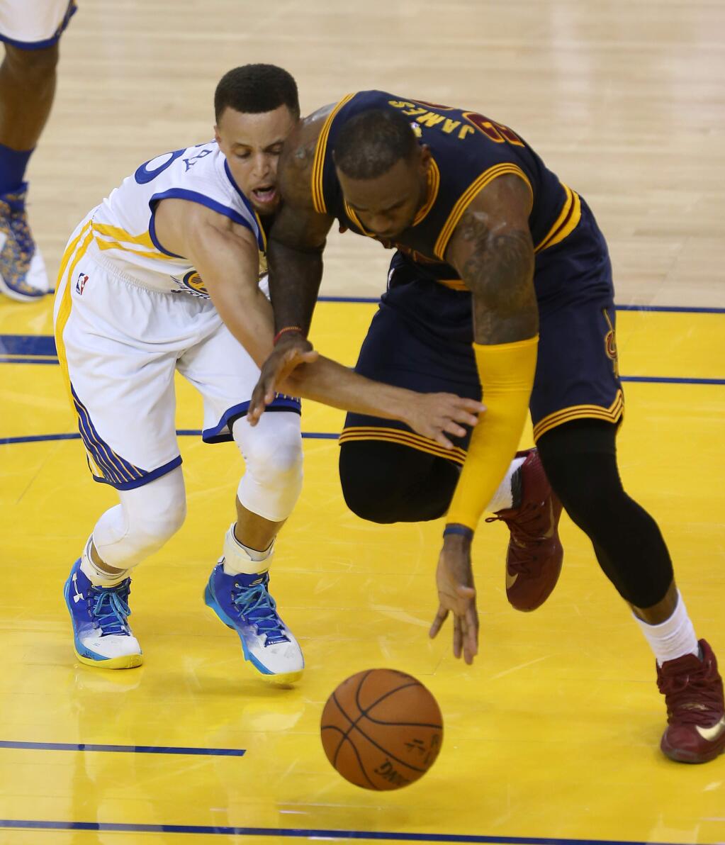 Golden State Warriors' Stephen Curry and Cleveland Cavaliers' LeBron James go after a loose ball during their game in Oakland on Thursday, June 2, 2016. (Christopher Chung / The Press Democrat)