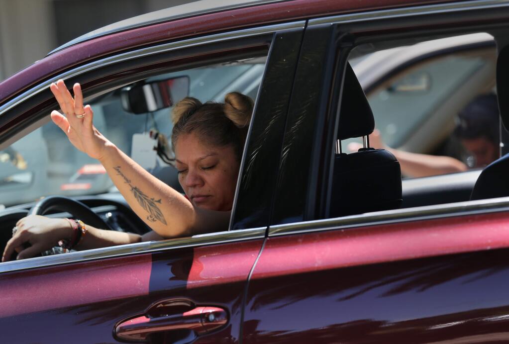 Leny Camara, left, and Kaye Martin, right, remain in their cars as they attend a Park-N-Praise service in Victory Outreach Santa Rosa church parking lot in Santa Rosa, Calif., on Sunday, May 24, 2020. (BETH SCHLANKER/ The Press Democrat)