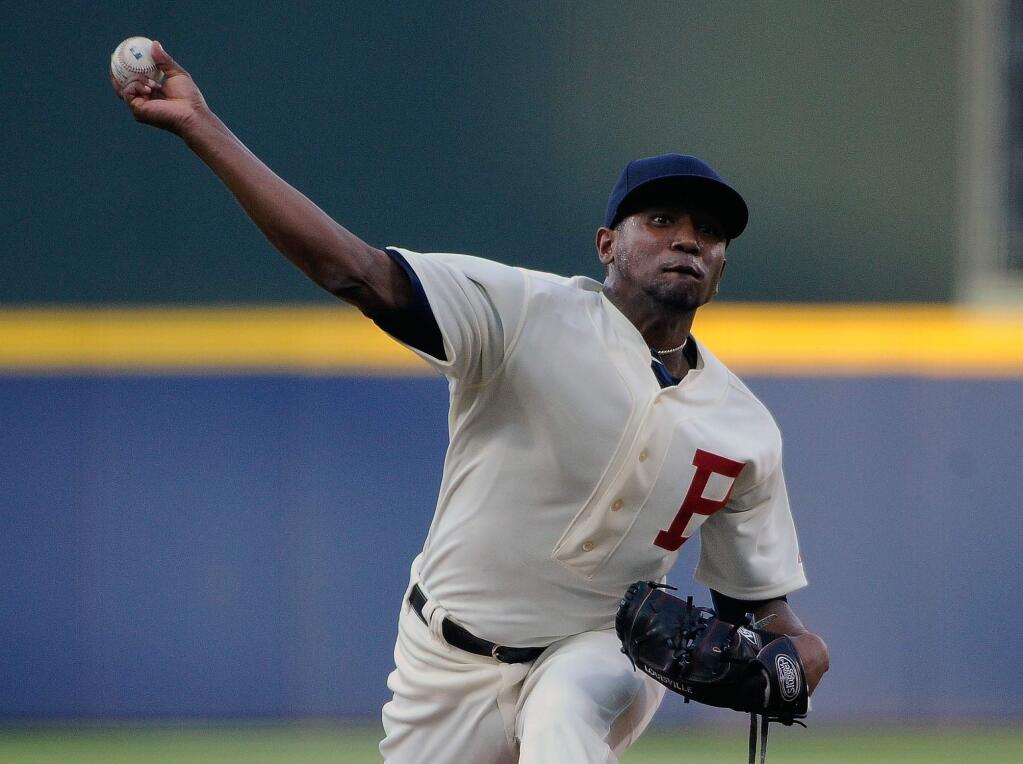 Wearing a 1914 throwback uniform to commemorate the World Series-winning Boston Braves, Atlanta Braves starting pitcher Julio Teheran delivers to the Oakland Athletics during the first inning of a baseball game Saturday, Aug. 16, 2014, in Atlanta. (AP Photo/David Tulis)