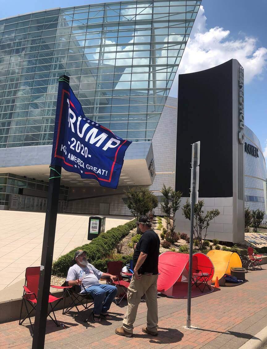 FILE - In this June 16, 2020, file photo James Massery, left, of Preston, Okla., and Daniel Hedman, of Tulsa, Okla., supporters of President Donald Trump, camp outside the BOK Center in Tulsa four days before his scheduled rally Saturday. President Donald Trump's campaign says six staff members helping set up for his Saturday night rally in Tulsa, Oklahoma, have tested positive for coronavirus. (AP Photo/Tom McCarthy, File)