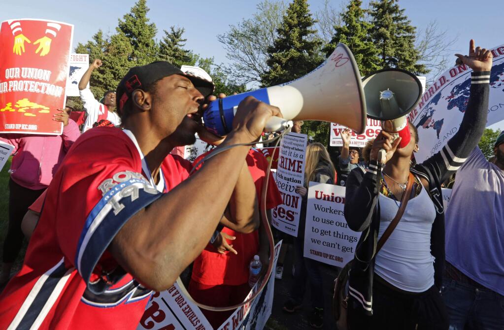In this May 22, 2014 file photo, protesters gather outside of the McDonald's Corporation headquarters in Oak Brook, Ill., the annual shareholders meeting demonstrating for higher wages and the right to unionize. (AP Photo/M. Spencer Green, File)
