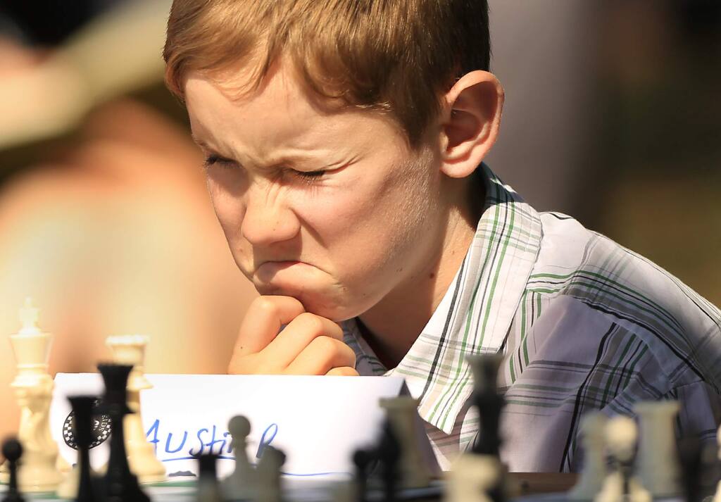 Austin Richter, 10, of Santa Rosa contemplates his next move against Los Angeles-based Armenian-born American chess grandmaster Varuzhan Akobian as he and others from Santa Rosa's Chess for Kids played Akobian at Paradise Ridge Winery in Santa Rosa on Monday, June 6, 2016. (KENT PORTER/ PD)
