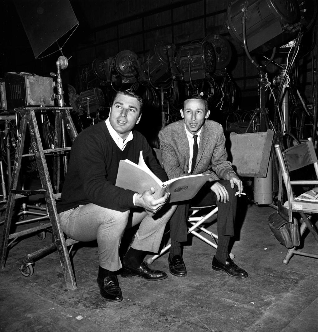 Ron Miller, left, son-in-law of Walt Disney, and Roy E. Disney, Walt's nephew, check over plans for future productions on the set of their last movie at Disney studios in Burbank, Ca., Dec. 1, 1967. (AP Photo)