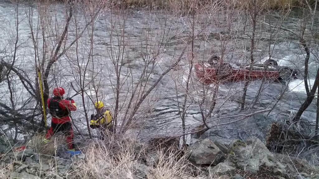 In this photo taken Wednesday, Dec. 12, 2018, provided by Cal Fire, the Siskiyou County Sheriff's dive team works at the scene where a man survived for hours trapped in his upside-down car after it plunged into a frigid river, near Yreka, Calif. (Cal Fire via AP)