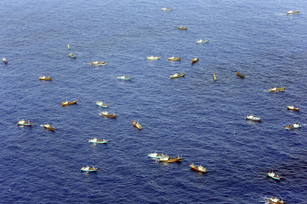 Foreign vessels, some of them have Chinese flags, sail near Torishima, Japan, on Oct. 31, 2014. A Chinese scientific ship bristling with surveillance equipment docked in a Sri Lankan port. Hundreds of fishing boats anchored for months at a time among disputed islands in the South China Sea. And ocean-going ferries, built to be capable of carrying heavy vehicles and large loads of people. (Kyodo News via AP)
