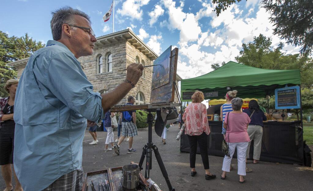 Keith Wicks, founder of the Plain Air event fifteen years ago, works on his painting of Mike the Baker's stall at the farmers market. The 'Quickdraw' part of the Plein Air event took place Tuesday on the Plaza. Artists are given an hour-and-a-half to complete their paintings, which are then put on display and sold. (Photo by Robbi Pengelly/Index-Tribune)