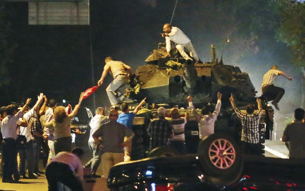 A tank moves into position as Turkish people attempt to stop them, in Ankara, Turkey, early Saturday, July 16, 2016. Members of Turkey's armed forces said they had taken control of the country Friday as explosions, gunfire and a reported air battle between loyalist forces and coup supporters erupted in the capital. President Erdogan remained defiant and called on people to take to the streets to show support for his embattled government. (AP Photo)
