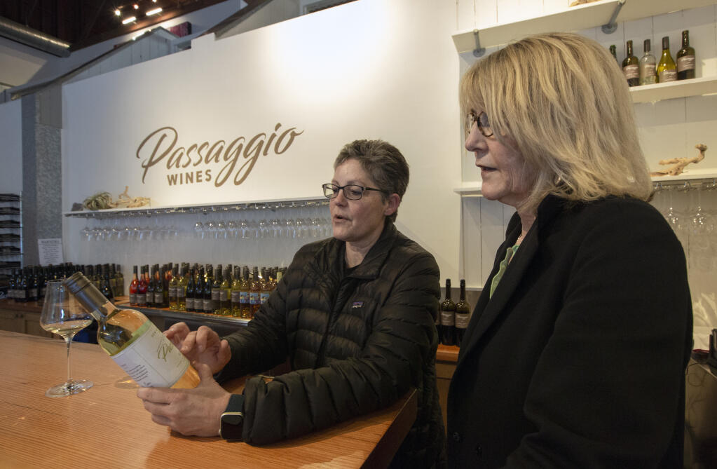 Owner and winemaker Cindy Cosco, left, and tasting room manager Carole Martinson discuss the design of one of the wine labels in the Passagio Wines tasting room at Jack London Village in Glen Ellen on Arnold Drive on Friday, Jan. 20, 2023. (Robbi Pengelly/Index-Tribune)
