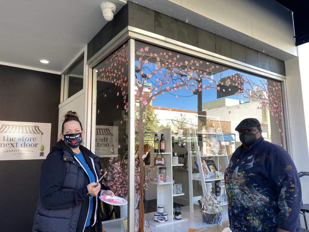 Terrence Howell and his assistance create the window art you see at businesses such as Oliver’s Market, Mac’s Deli, ER Sawyer Jewelers. Here they were painting beautiful cherry tree blossoms on the windows of The Store Next Door. Leslie Graves photo.