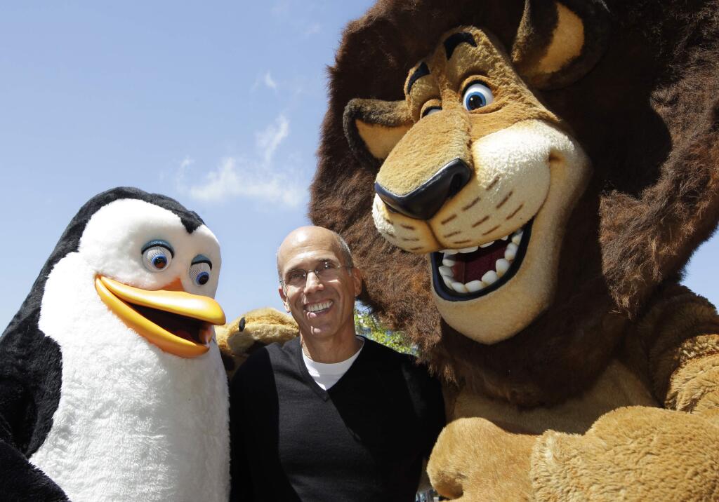 FILE - In this Thursday, July 19, 2012, file photo, DreamWorks Animation CEO Jeffrey Katzenberg, center, plays with Madagascar characters, Alex the lion, right, and Kowalski the penguin, left, during a groundbreaking opening of DreamWorks studios in Redwood City, Calif. Comcast is buying DreamWorks Animation, the film company behind the Shrek, Madagascar and Kung Fu Panda franchises, for approximately $3.55 billion, the companies announced Thursday, April 28, 2016. DreamWorks will become part of the Universal Filmed Entertainment Group, which includes Universal Pictures. Once the deal closes, DreamWorks co-founder and CEO Katzenberg will become chairman of DreamWorks New Media. He'll also serve as a consultant to NBCUniversal, a unit of Comcast Corp. (AP Photo/Paul Sakuma, File)