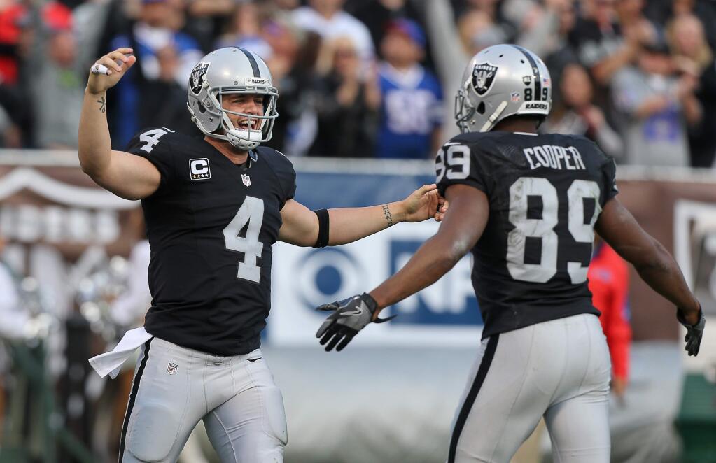 Oakland Raiders quarterback Derek Carr, left, and wide receiver Amari Cooper celebrate connecting for a touchdown in the fourth quarter against the Buffalo Bills in Oakland on Sunday, Dec. 4, 2016. (Christopher Chung / The Press Democrat)