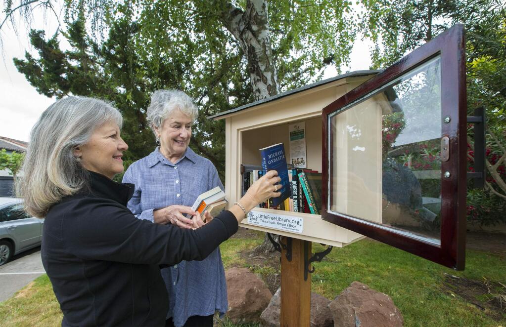 Judy Radican (left) and Patricia Brooks built, stocked and maintain the mini-library on Blue Wing Drive and Second St. East. Little Free Libraries, a nationwide movement to encourage literacy, have cropped up all over the valley. The birdhouse-like structures, filled with books of all kinds, encourage visitors to take a book and return a book. (Photo by Robbi Pengelly/Index-Tribune)