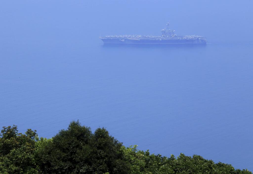 USS Carl Vinson sails in Danang Bay Monday, March 5, 2018 in Danang, Vietnam. For the first time since the Vietnam War, the U.S. Navy aircraft carrier is visiting a Vietnamese port, seeking to bolster both countries' efforts to stem expansionism by China in the South China Sea. (AP Photo/Hau Dinh)