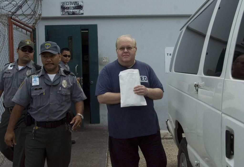 FILE- In this June 15, 2007, file photo, Lou Pearlman, right, is escorted to an awaiting van in Yigo, Guam. Pearlman, credited for starting the boy-band craze and launching the careers of the Backstreet Boys and ‘NSync, has died in prison while serving a 25-year sentence for a massive Ponzi scheme. The Orlando Sentinel reported that according to a federal inmate database, the 62-year-old Pearlman died Friday, Aug. 19, 2016. (Masako Watanabe/The Pacific Daily via AP, File) MANDATORY CREDIT