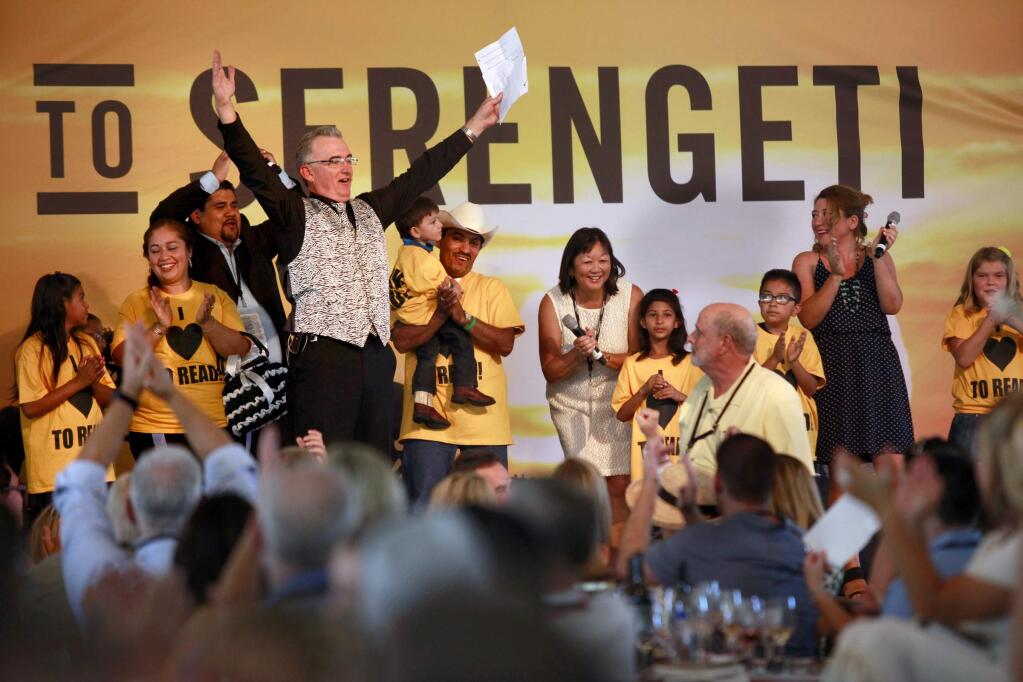 Auctioneer Scott Robertson responds after Joe Anderson of Benovia Winery announces a $200,000 donation to Fund the Future during the Sonoma Harvest Wine Auction at Chateau St. Jean on Sunday, Aug. 31, 2014 in Kenwood, California. (BETH SCHLANKER/ PD)