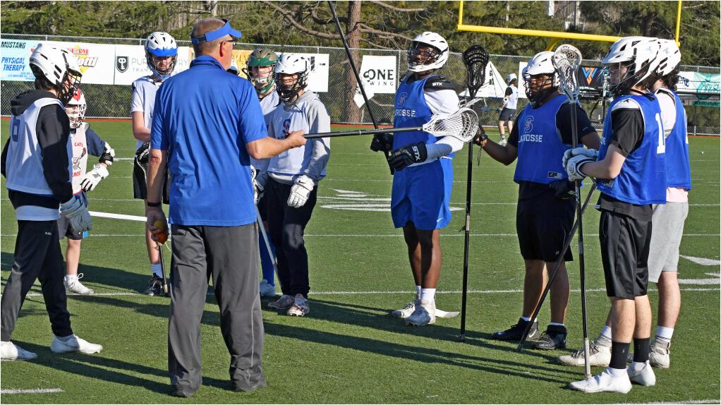 St. Vincent lacrosse players gahter around coach Ed Evans at a practice on Feb. 16, 2022. The Mustangs will play a full varsity schedule this year. (SUMNER FOWLER / FOR THE ARGUS-COURIER)