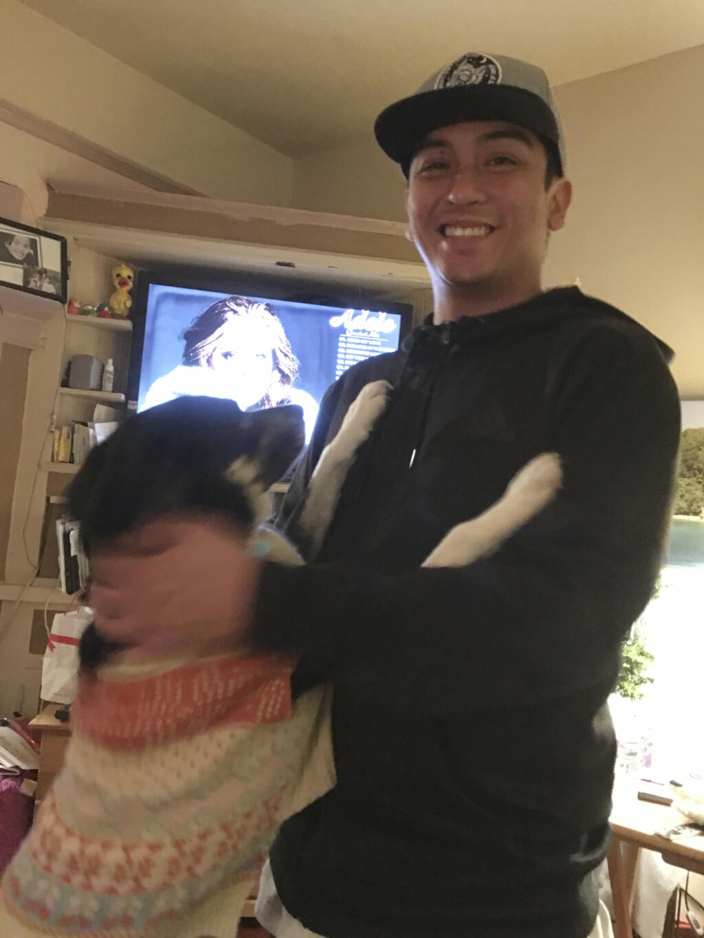 This Jan. 4, 2018 photo provided by Isabella Collins, Navy veteran Angelo Quinto smiles at his home in Berkeley, Calif. Quinto who was going through an episode of paranoia died after a Northern California police officer knelt on his neck for several minutes, his family said Tuesday, Feb. 23, 2021. The family called police on Dec. 23 because the 30-year-old was suffering a mental health crisis and needed help. His family says a responding officer knelt on Quinto's neck for nearly five minutes while another officer restrained him. He lost consciousness and was taken by ambulance to a hospital, where he died three days later. (Isabella Collins via AP)