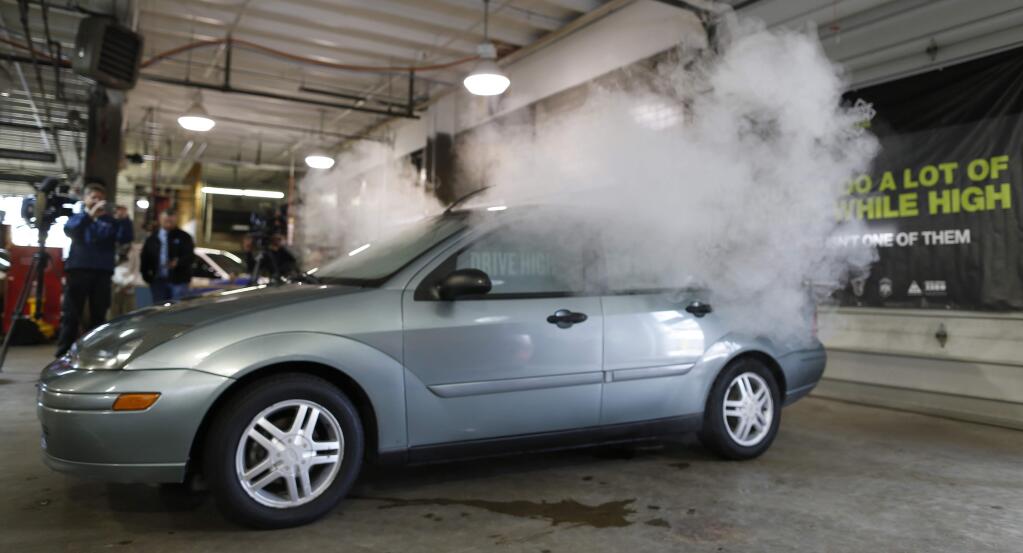FILE - In this April 16, 2015 file photo, smoke created by water vapor billows out of the windows of a car, used by Colorado to fight stoned driving with youth demographics, during a demonstration by the Colorado Department of Transportation in southeast Denver. The Highway Loss Data Institute, a leading insurance research group, said in study results released Thursday that collision claims in Colorado, Washington, and Oregon went up 2.7 percent in the years since legal recreational marijuana sales began when compared with surrounding states. (AP Photo/David Zalubowski, file)