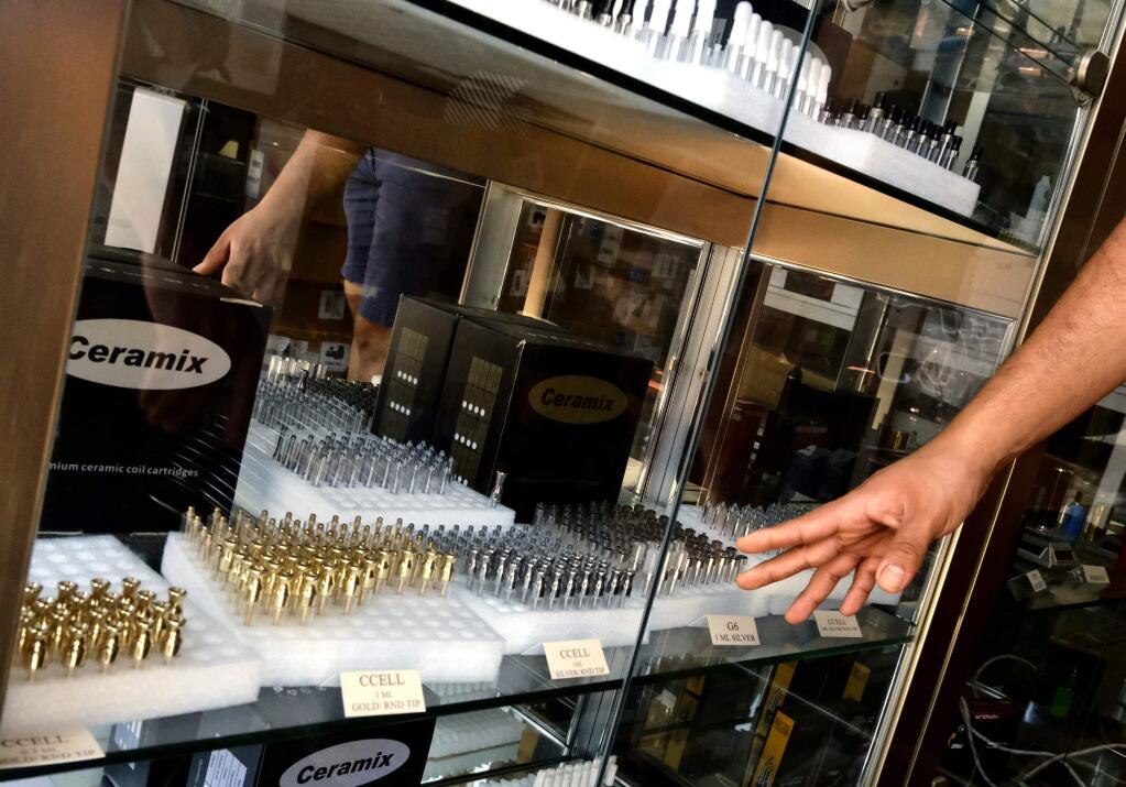 In this Wednesday, Aug. 28, 2019, photo, a shopkeeper shows his selection of refillable cannabis vape cartridges being sold at a wholesale shop in downtown Los Angeles. A short walk from police headquarters in the heart of downtown, a cluster of bustling shops are openly selling packaging and hardware that can be used to produce counterfeit, and potentially dangerous, marijuana vapes that have infected California's cannabis market and possibly sickened dozens of people. (AP Photo/Richard Vogel)