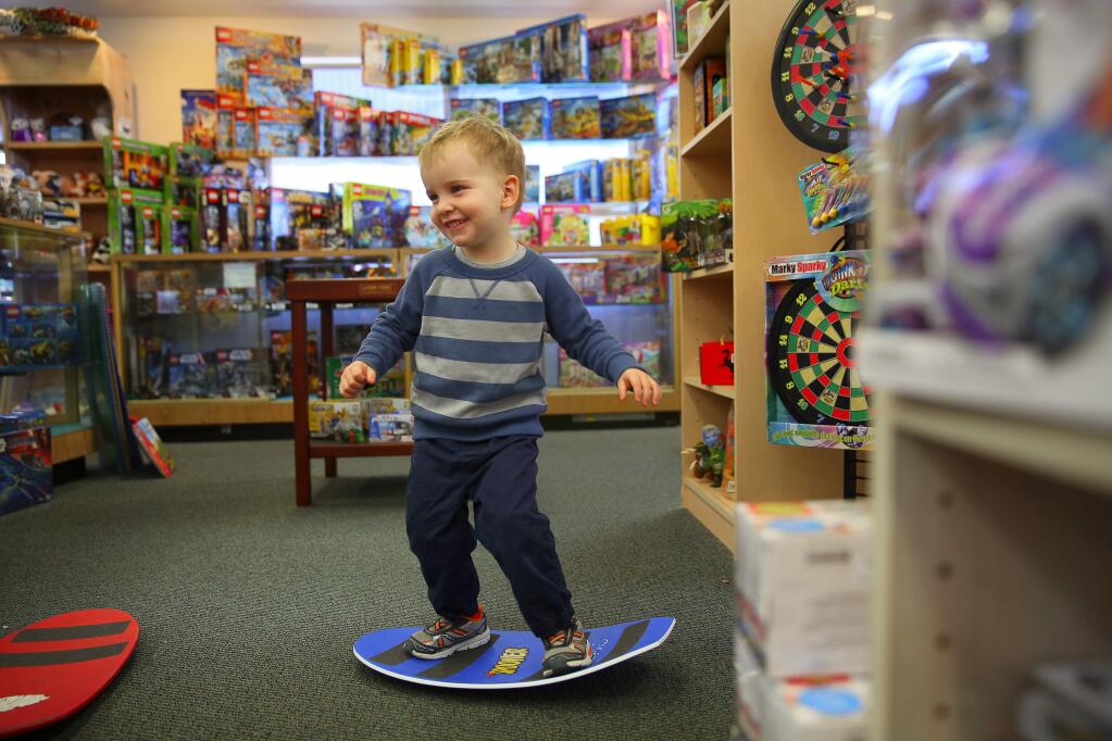Three-year-old Nolton Gierhart tries out the Spooner toy at The Toyworks, in Santa Rosa, on Thursday, November 19, 2015. (Christopher Chung/ The Press Democrat)