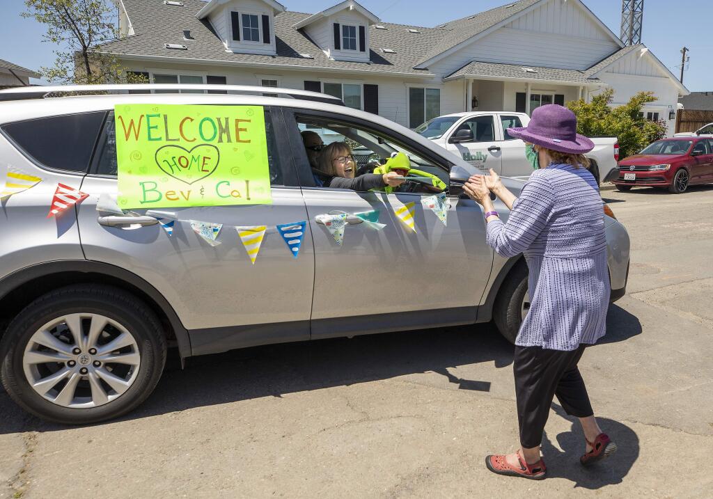 Mike and Leslie VanDordrecht were some of the dozens of neighbors dropping gifts or just driving by to welcome back Beverly Nystrom, 86, right, to her rebuilt Larkfield Estates home she originally moved into nearly 50 years ago. (John Burgess/The Press Democrat)