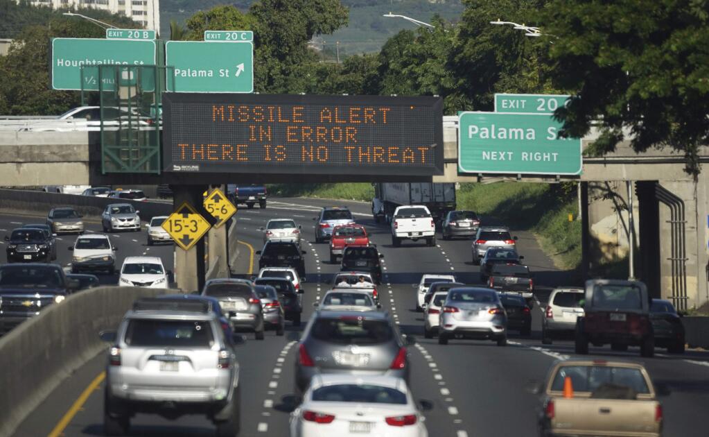 In this Saturday, Jan. 13, 2018 photo provided by Civil Beat, cars drive past a highway sign that says 'MISSILE ALERT ERROR THERE IS NO THREAT' on the H-1 Freeway in Honolulu. The state emergency officials announced human error as cause for a statewide announcement of an incoming missile strike alert that was sent to mobile phones. (Cory Lum/Civil Beat via AP)