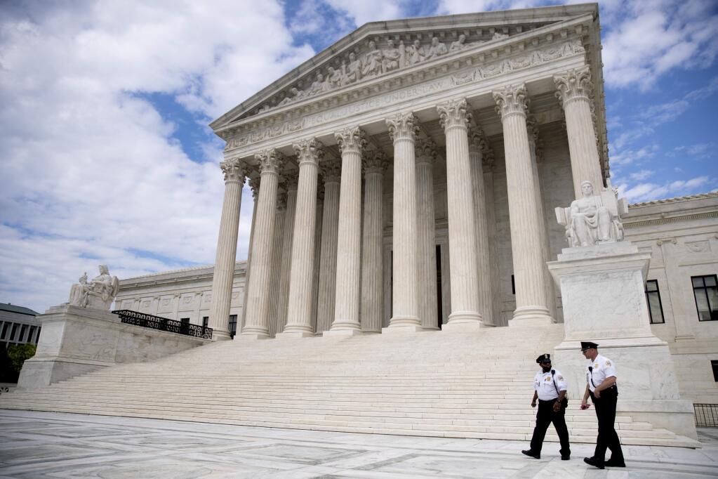 Security officers, one wearing a mask, walk in front of the Supreme Court, Thursday, May 14, 2020, in Washington. (AP Photo/Andrew Harnik)