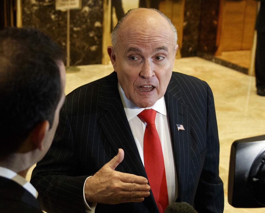FILE - In this Jan. 12, 2017, file photo, former New York City Mayor Rudy Giuliani talks with reporters in the lobby of Trump Tower in New York. Giuliani's revelation that U.S. President Donald Trump reimbursed his personal attorney for a $130,000 payment to a porn star to keep her quiet about an alleged affair is raising new legal questions, including whether the president and his campaign violated campaign finance laws. Giuliani insisted on Fox News Channel Wednesday night, May 2, 2018, that the payment to adult film actress Stormy Daniels was 'going to turn out to be perfectly legal.' (AP Photo/Evan Vucci, File)