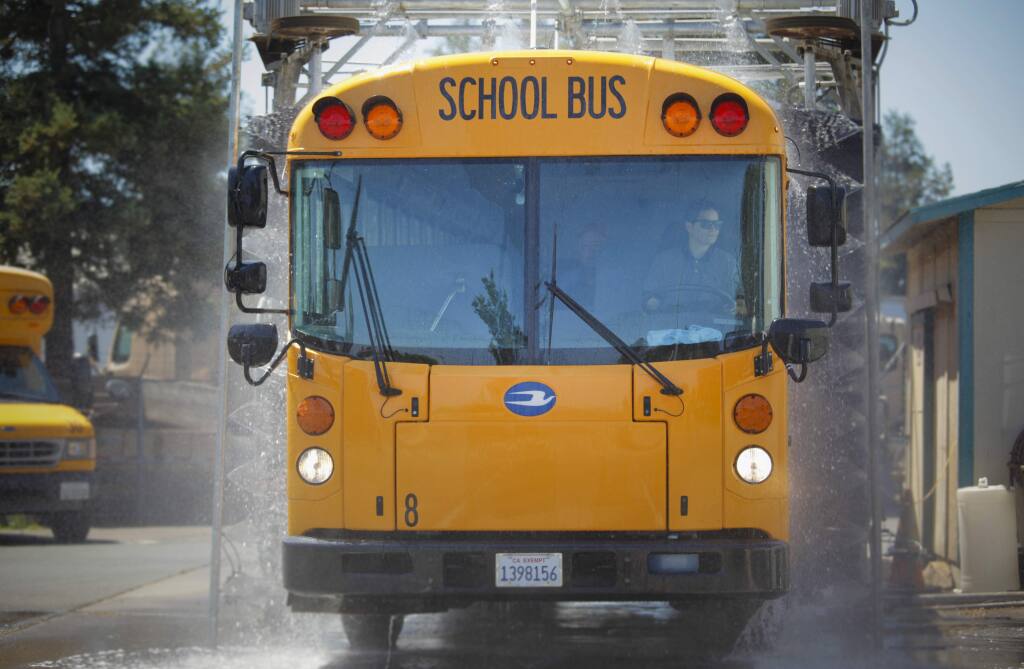 A Petaluma City Schools bus runs through the wash in this August 2019 Argus-Courier file photo. (CRISSY PASCUAL/ARGUS-COURIER STAFF)