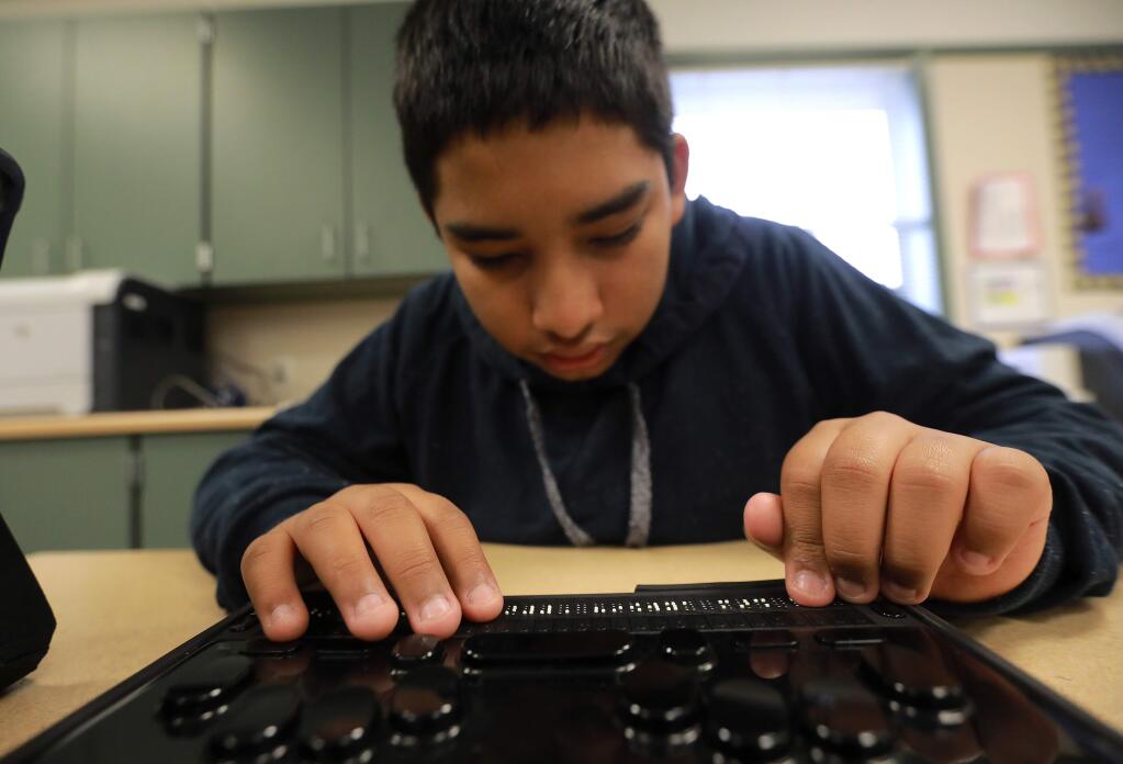 Rincon Valley Charter School 8th grader Mario Chitwood sets up the preferences on his new braille after the blind student lost everything when his Coffey Park home burned in the Tubbs fire. The maker of the braille computer, HIMS, Inc., replaced the device $5,000 device at no cost to Chitwood. (photo by John Burgess/The Press Democrat)