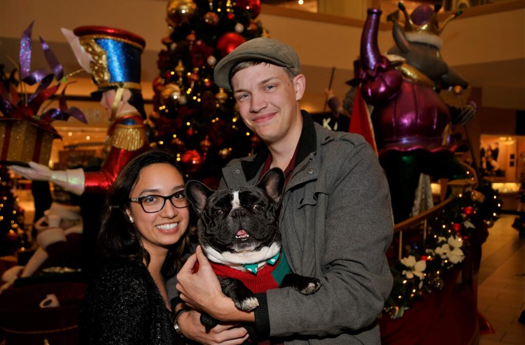 Joelle Kline and Chase Ferrante took their French bulldog Phillip to the Santa Rosa Plaza, Sunday Dec. 10, for photos with Santa. (Will Bucquoy/For the Press Democrat)