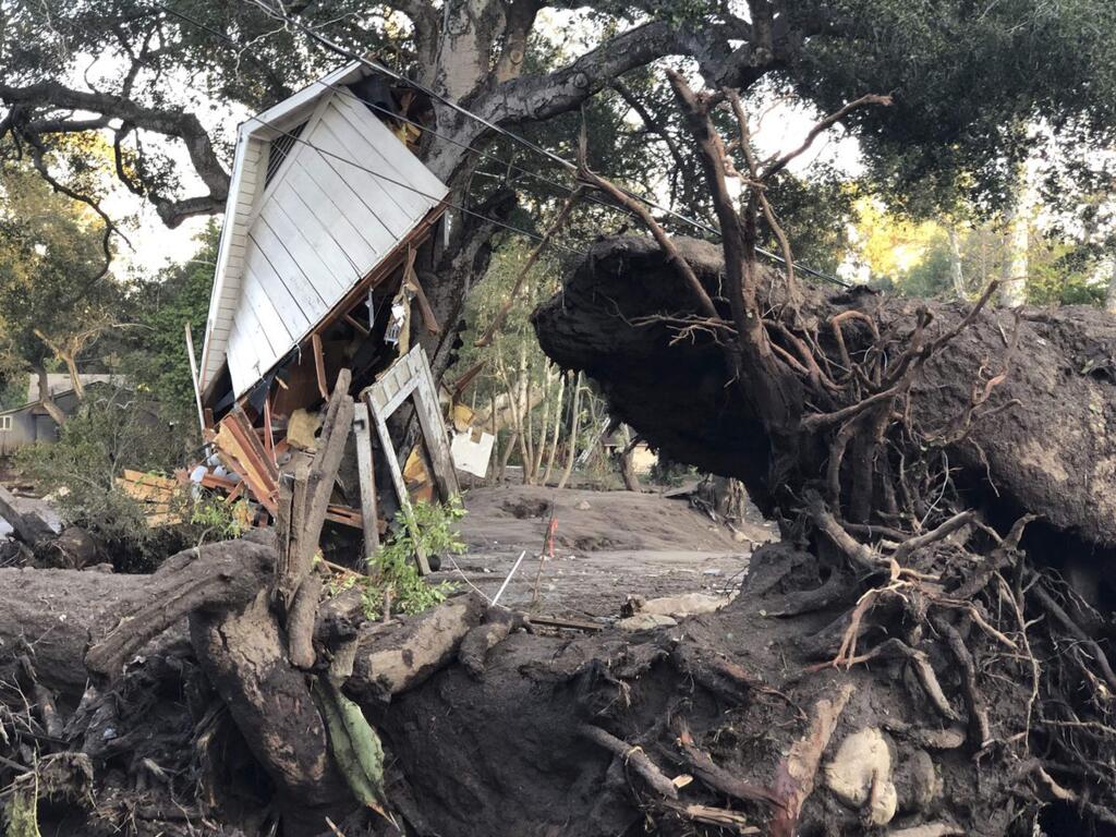 This photo provided by the Santa Barbara County Fire Department shows mud, boulders, and debris that destroyed homes that lined Montecito Creek near East Valley Road in Montecito, Calif., Wednesday, Jan. 10, 2018. Anxious family members awaited word on loved ones Wednesday as rescue crews searched grimy debris and ruins for more than a dozen people missing after mudslides in Southern California on Tuesday destroyed over a 100 houses, swept cars to the beach and left more than a dozen victims dead. (Mike Eliason/Santa Barbara County Fire Department via AP)