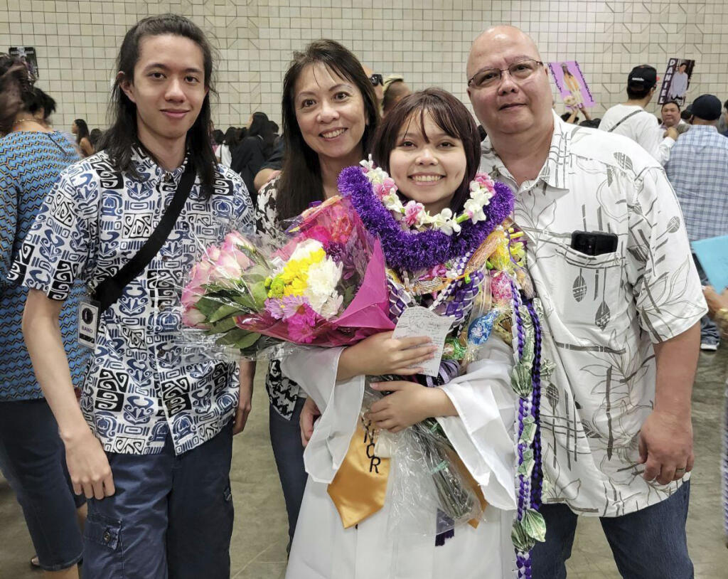 In this photo provided by Vernon Tyau, Jarek Agcaoili, left, with his mother Danielle, sister Jessika and father Maury Agcaoili pose in May 2023, at Jessika's high school graduation in Hawaii. Danielle and Maury Agcaoili were among boaters who died Sunday, May 28, 2023, near Sitka, Alaska, when a fishing vessel ran into trouble in rough seas. (Vernon Tyau via AP)