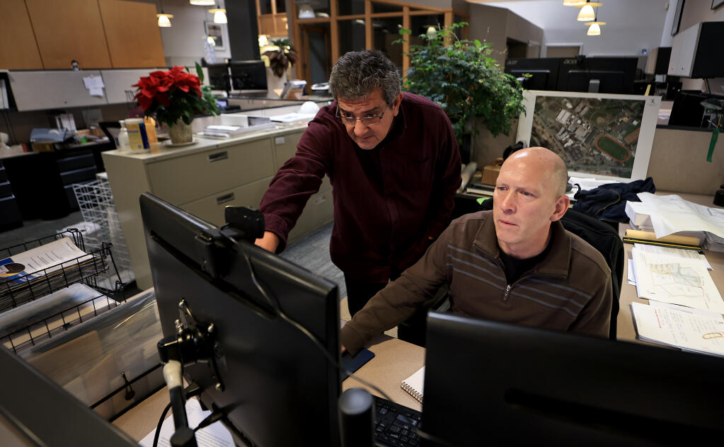 Cam Hawing, project designer, left, and John Dybczak a partner of Quattrocchi Kwok Architects firm in Santa Rosa, collaborate on a project, Wednesday, Dec. 15, 2021. California's new mask mandate for businesses is in effect, but “stable cohorts or vaccinated individuals” like Quattrocchi Kwok, are exempt from the latest health order. (Kent Porter / The Press Democrat) 2021