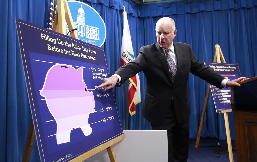 California Gov. Jerry Brown points to a chart showing the growth of the state's rainy day fund as as he discusses his proposed 2018-19 state budget Wednesday in Sacramento. (RICH PEDRONCELLI / Associated Press)