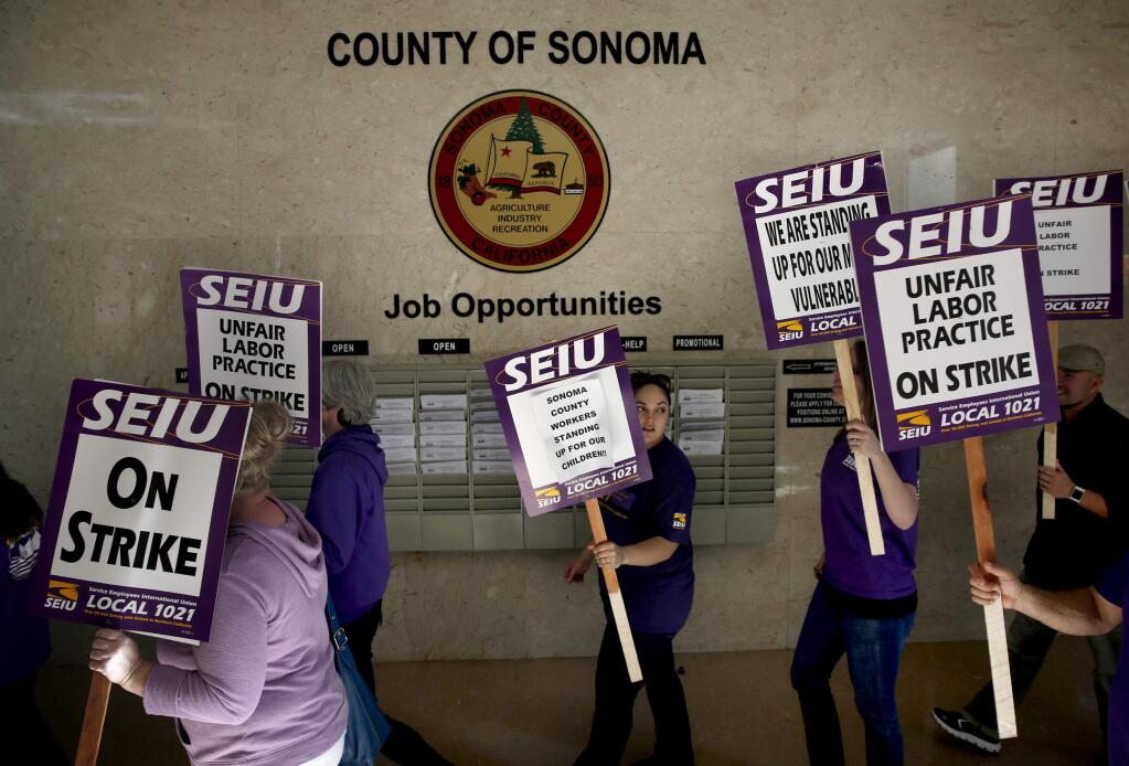 Members of the Service Employees Union Local 1021 walk through the Sonoma County Administration Building in Santa Rosa, on Tuesday, November 17, 2015. (BETH SCHLANKER/ The Press Democrat)
