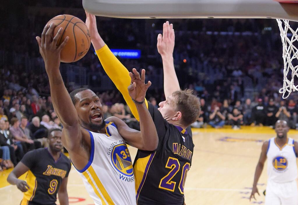 Golden State Warriors forward Kevin Durant, left, shoots as Los Angeles Lakers center Timofey Mozgov defends during the first half Friday, Nov. 25, 2016, in Los Angeles. (AP Photo/Mark J. Terrill)