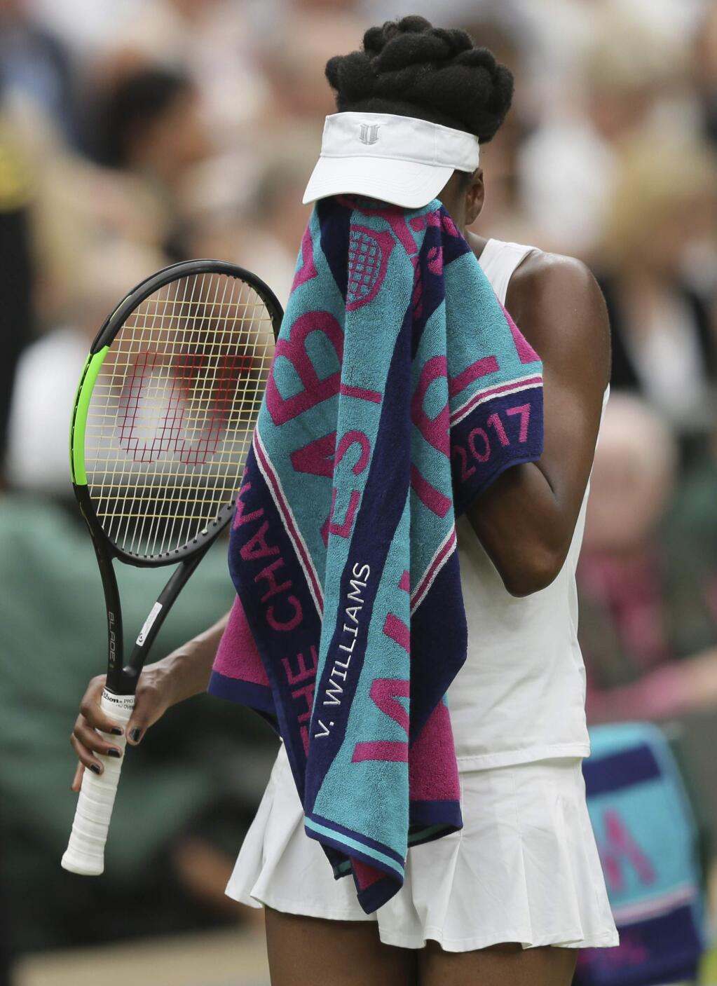 Venus Williams of the United States wipes her face as she plays Spain's Garbine Muguruza during the Women's Singles final match on day twelve at the Wimbledon Tennis Championships in London Saturday, July 15, 2017. (AP Photo/Tim Ireland)