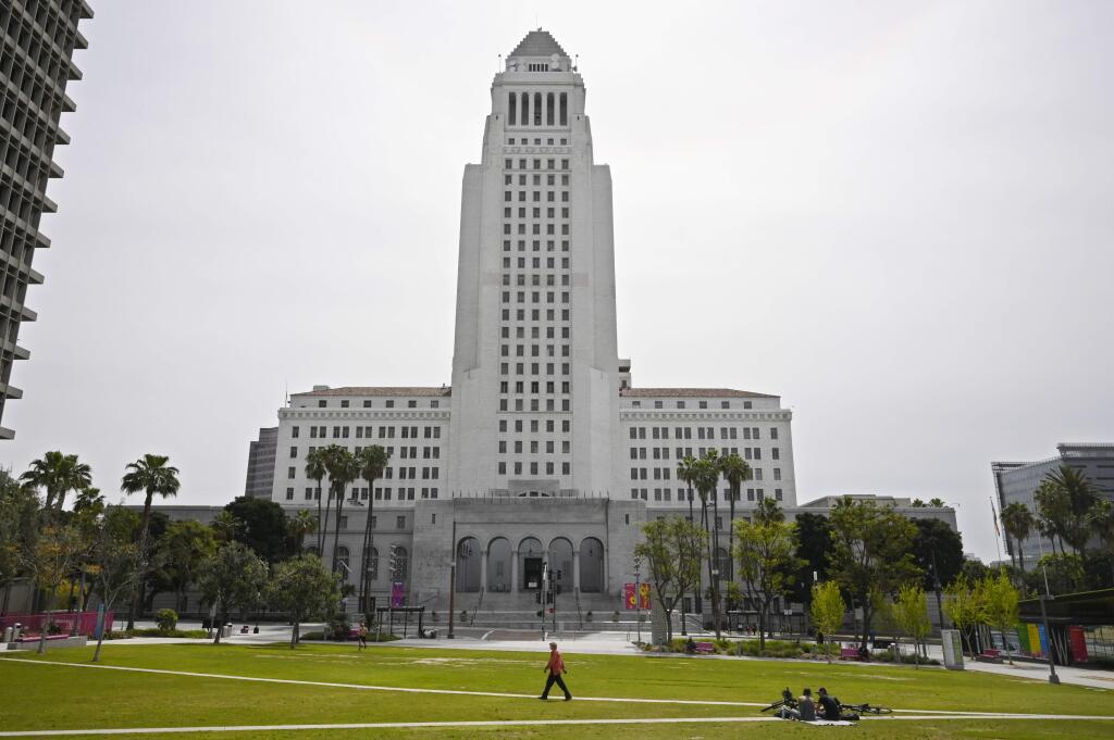 A few people use Grand Park at the foot of Los Angeles City Hall, Tuesday, March 31, 2020, in Los Angeles. The new coronavirus causes mild or moderate symptoms for most people, but for some, especially older adults and people with existing health problems, it can cause more severe illness or death. (AP Photo/Mark J. Terrill)