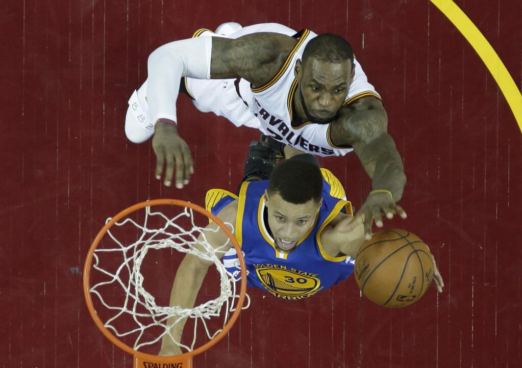 Golden State Warriors' Stephen Curry, bottom, drives to the basket against Cleveland Cavaliers' LeBron James in the second half in Game 6 of the NBA Finals, Thursday, June 16, 2016, in Cleveland. The Cavaliers won 115-101. (AP Photo/Ron Schwane)